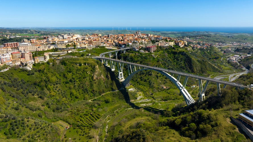 Aerial view of the historic center of Catanzaro and the famous access bridge to the city. It is the capital of Calabria, southern Italy. In the background is the Ionian Sea.