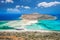 photo of view of Balos lagoon on Crete island, Greece. Tourists relax and bath in crystal clear water of Balos beach.,vMunicipality of Kissamos, Greece.