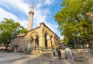 Touristic sightseeing ships in Golden Horn bay of Istanbul and mosque with Sultanahmet district against blue sky and clouds. Istanbul, Turkey during sunny summer day.