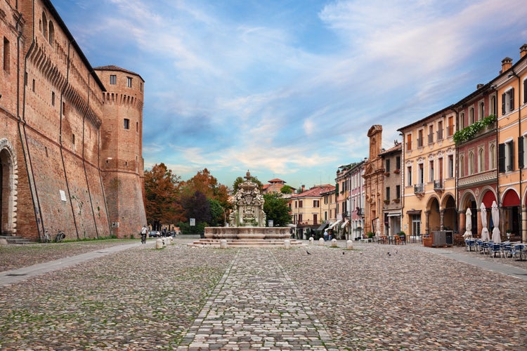 Photo of landscape of the ancient square Piazza del Popolo with the fortified palace Rocchetta di Piazza and the fountain Fontana del Masini in the old town of the city Cesena, Emilia-Romagna, Italy.