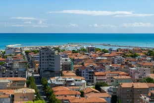 Photo of beach chairs, on a sandy, shoreline, in Giulianova, Italy.