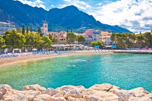 Photo of panorama and landscape of Makarska resort and its harbour with boats and blue sea water, Croatia.