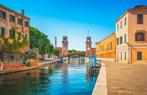 photo of view Venetian Arsenal with docks, canal and industrial building in a sunny day in Venice, Italy.