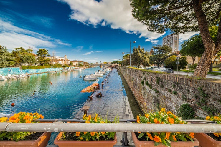 Photo of Bridge on Rimini canal port with boats, modern buildings and old houses.