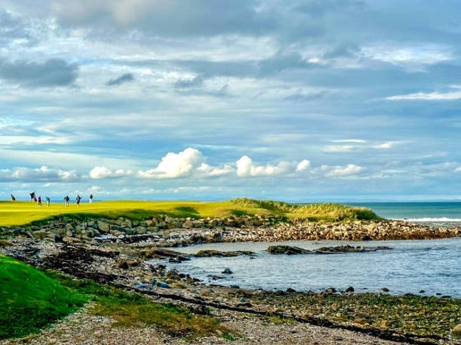 Golfers playing on the signature 15th hole, along the shores of Kingsbarns Golf Course, just outside St Andrews, Scotland.jpg