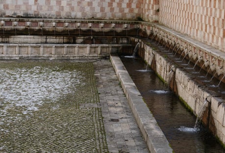 Fountain of the 99 Spouts (Fontana delle 99 cannelle), Historic fountain with 99 jets distribuited along three walls, L Aquila, Italy.