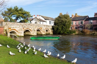 Photo of a stone bridge spans the River Avon, Christchurch, Dorset, England on a hot summer day.