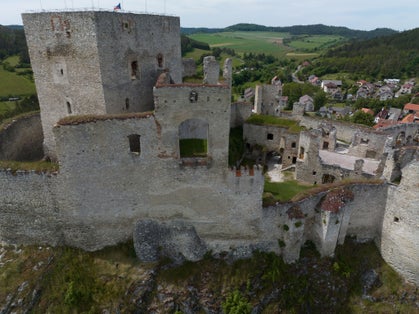 Photo of Rabi castle, largest medieval fortress ruin in the Czech Republic with concentric walls and round towers.