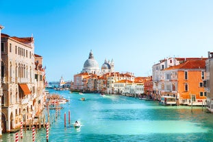 Famous buildings, gondolas and monuments by the Rialto Bridge of Venice on the Grand Canal, Italy.