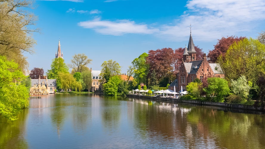 Bruges in Belgium, beautiful typical houses on the canal, and a church in background