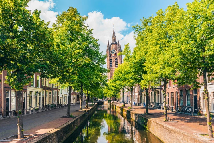 photo of Oude Delft canal and leaning tower of Gothic Protestant Oude Kerk church, Delft, Holland, Netherlands.