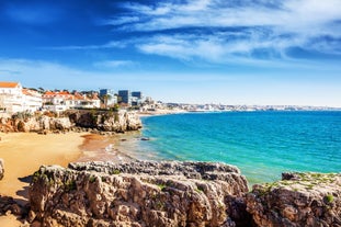 Photo of aerial view over People Crowd Having Fun On Beach And Over Cascais City In Portugal.