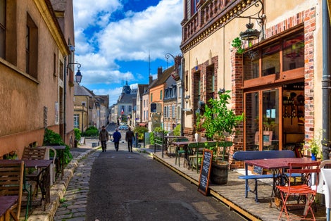 Old street with old houses and tables of cafe in a small town Chartres, France