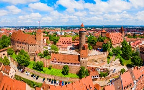 Photo of scenic summer view of the German traditional medieval half-timbered Old Town architecture and bridge over Pegnitz river in Nuremberg, Germany.