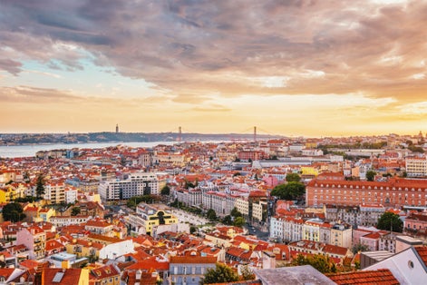 Photo of view of Lisbon famous view from Miradouro da Senhora do Monte tourist viewpoint of Alfama and Mauraria old city district at sunset, Portugal.