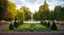 photo of flower arrangements in symmetrical shapes leading up to a fountain in the city park Stadsparken in the town Lund, Sweden.