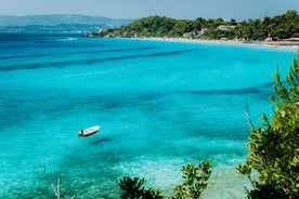 Photo of white boat in crystal clear blue sea water, Argostoli, Greece.