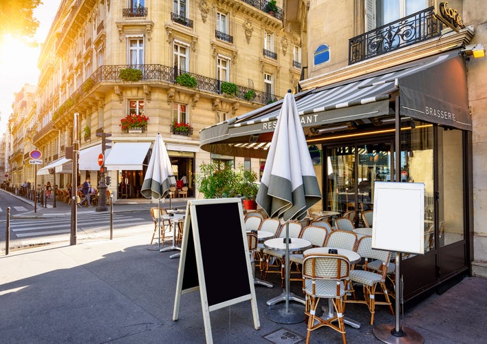 Typical view of the Parisian street with tables of brasserie (cafe) in Paris, France.