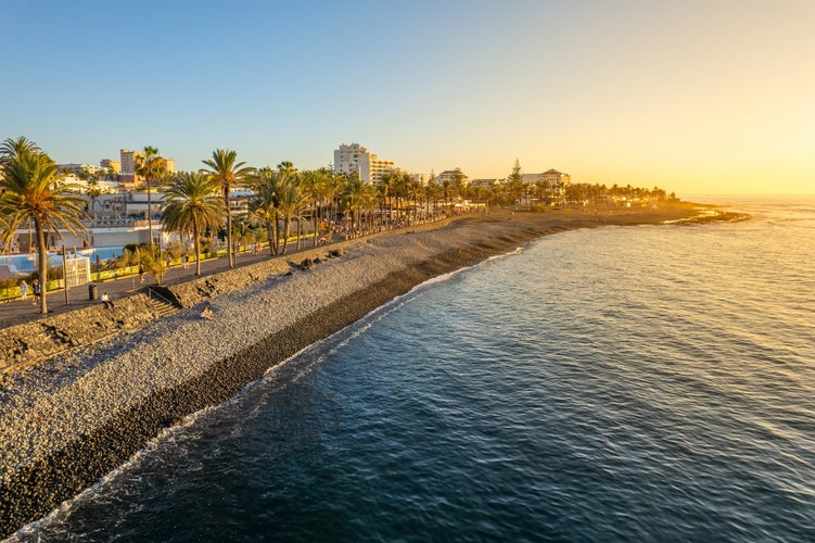 Photo of aerial view of beautiful beach and ocean coast in Adeje Playa de las Americas at sunset, Tenerife, Canary islands, Spain.