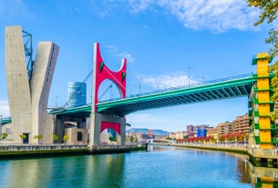 Photo of aerial view of Vizcaya bridge over the river and cityscape at Portugalete, Spain.