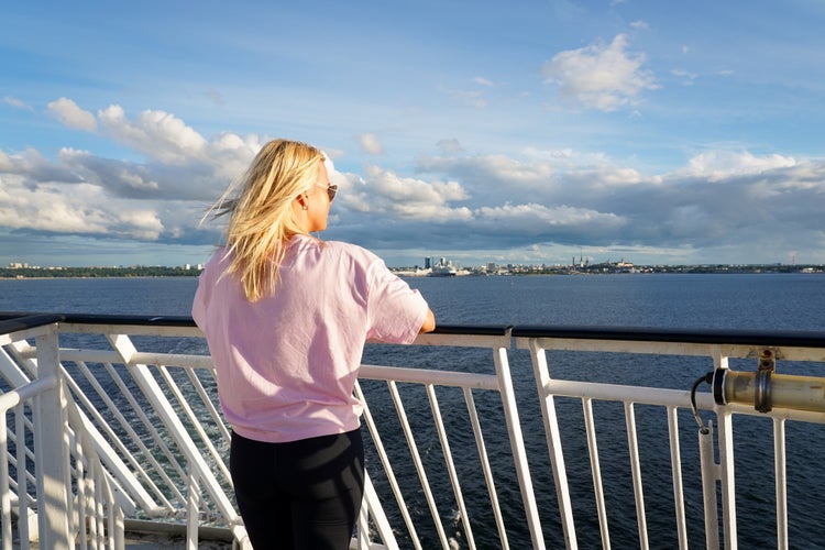 Photo of a tourist on the deck of a ship sailing from Tallinn, Estonia.