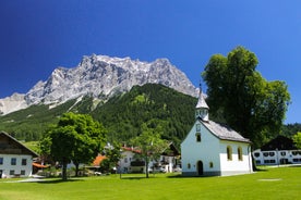 Photo of a view of the Alps from the Ehrwald, a town on the border of Germany and Austria with picturesque meadows surrounded by towering mountain ranges, including the Zugspitze.