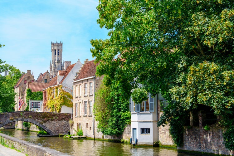 Scenic canal with colorful houses and lush trees in Bruges, Belgium.jpg