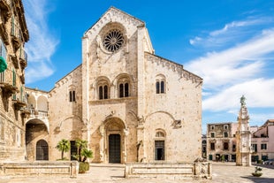 Photo of panoramic view of the ancient town of Matera (Sassi di Matera), European Capital of Culture 2019, in beautiful golden morning light with blue sky and clouds, Basilicata, southern Italy.