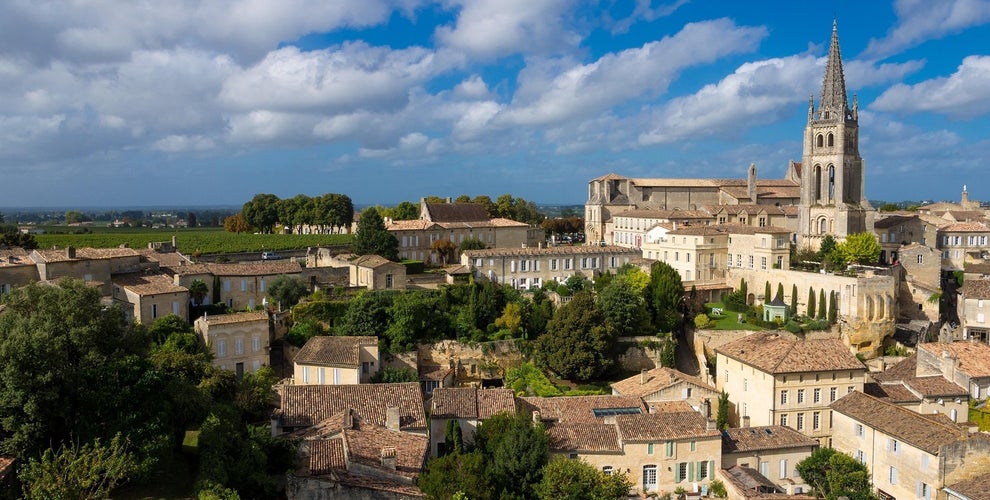Scenic view of Saint-Émilion village near Bordeaux, with vineyards and a historic church under a bright blue sky..jpg