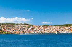 Photo of white boat in crystal clear blue sea water, Argostoli, Greece.