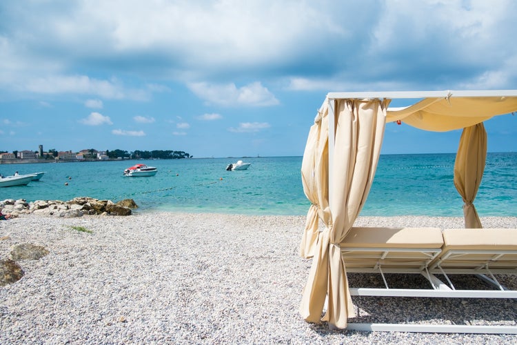 Summer view on Poreč from luxury baldachin on a pebble beach