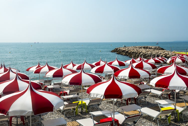 Cagnes-sur-Mer (Alpes-Maritimes, Provence-Alpes-Cote d'Azur, France), red and white umbrellas on the beach