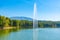 Photo of grand park in Tirana viewed behind a fountain on an artificial lake, Albania.