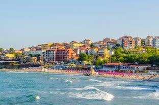 Photo of Saint Anastasia Island in Burgas bay, Black Sea, Bulgaria. Lighthouse tower and old wooden buildings on rocky coast.