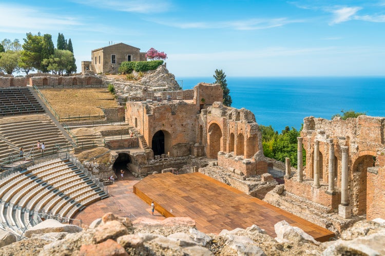 Ruins of the Ancient Greek Theater in Taormina on a sunny summer day with the mediterranean sea. Province of Messina, Sicily, southern Italy.