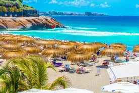 photo of aerial shot of Costa Adeje area, South Tenerife, Spain. Captured at golden hour, warm and vivid sunset colors. Luxury hotels, villas and restaurants behind the beach.