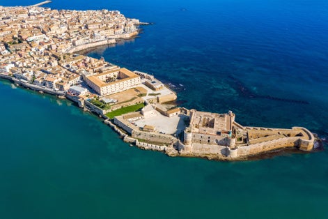 Siracusa, Ortigia Island from the air, Sicily, Italy. Isola di Ortigia, coast of Ortigia island at city of Syracuse, Sicily, Italy. Coastline town Syracuse, Sicily and old Ortigia island. Aerial view.