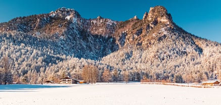 photo of Elevated, scenic view of the town of Bischofswiesen, Bavaria, Germany. The Watzmann Mountain, part of the Bavarian Alps rises into a majestic skyline. A green, spring landscape set in the valley.