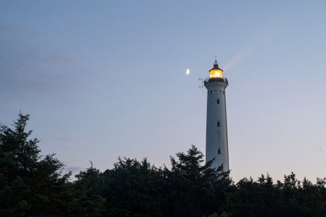 Photo of Lyngvig Lighthouse illuminated at night at the Danish West Coast, Denmark.