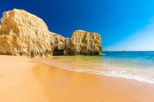 Photo of wide sandy beach in white city of Albufeira, Algarve, Portugal.