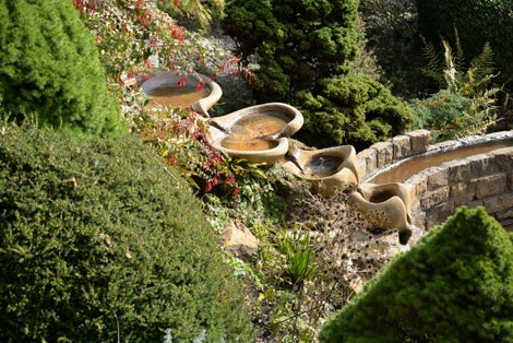 Photo of beautiful waterfall and Vesica Pool in the Chalice Well Garden, Glastonbury, England.