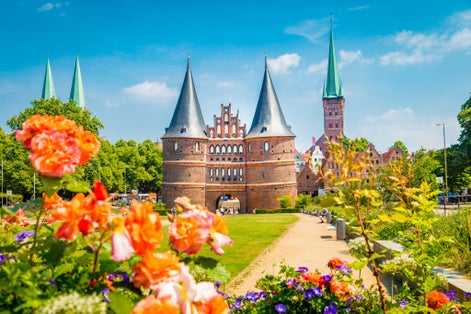 view of the historic town of Lübeck with famous Holstentor town gate on a beautiful sunny day with blue sky and clouds in summer, Schleswig-Holstein, northern Germany