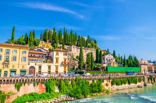 Photo of aerial view of Verona historical city centre, Ponte Pietra bridge across Adige river, Verona Cathedral, Duomo di Verona, red tiled roofs, Veneto Region, Italy.