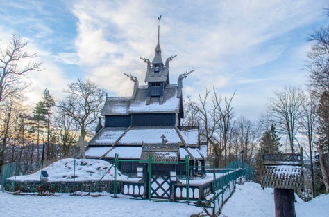 Old wooden Fantoft Stave Bergen Norway church in winter snow adn sunrise.