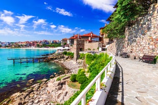 Photo of Saint Anastasia Island in Burgas bay, Black Sea, Bulgaria. Lighthouse tower and old wooden buildings on rocky coast.