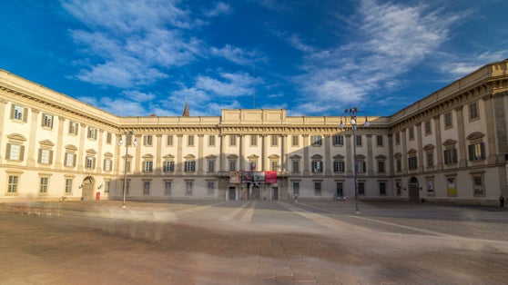 photo of The Royal Palace of Milan timelapse hyperlapse. It was the seat of government of the Italian city of Milan for many centuries, but today is an important cultural center. Blue cloudy sky at summer day.