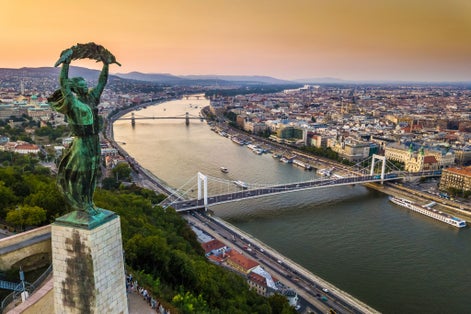 photo of Budapest, Hungary - The Hungarian Statue of Liberty at sunrise with Elisabeth Bridge and Szechenyi Chain Bridge and skyline of Budapest at background