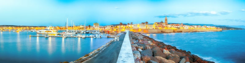 Photo of aerial view of Alghero on a beautiful day with harbor and open sea, Italy.