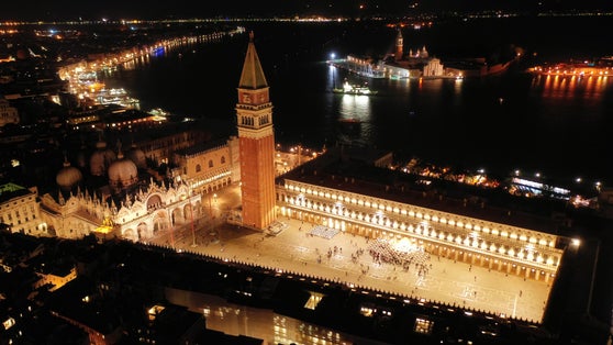Aerial drone night shot of iconic illuminated Saint Mark's square or Piazza San Marco featuring Doge's Palace, Basilica and Campanile, Venice, Italy.
