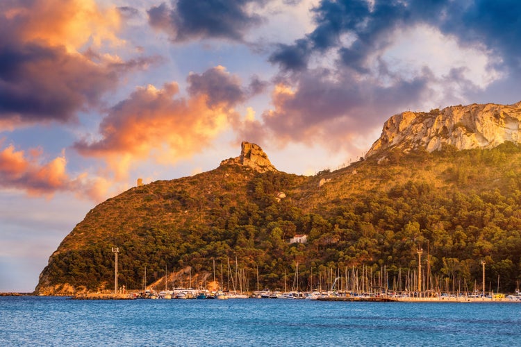 Beach of Cagliari (Poetto Sella del Diavolo) with Torre del Poetto tower and boats at sunset, Sardinia, Italy.